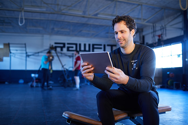 Man zit in zaal achter Ipad flexibel