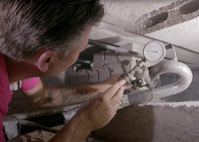 Een monteur is bezig met de aanleg van vloerisolatie