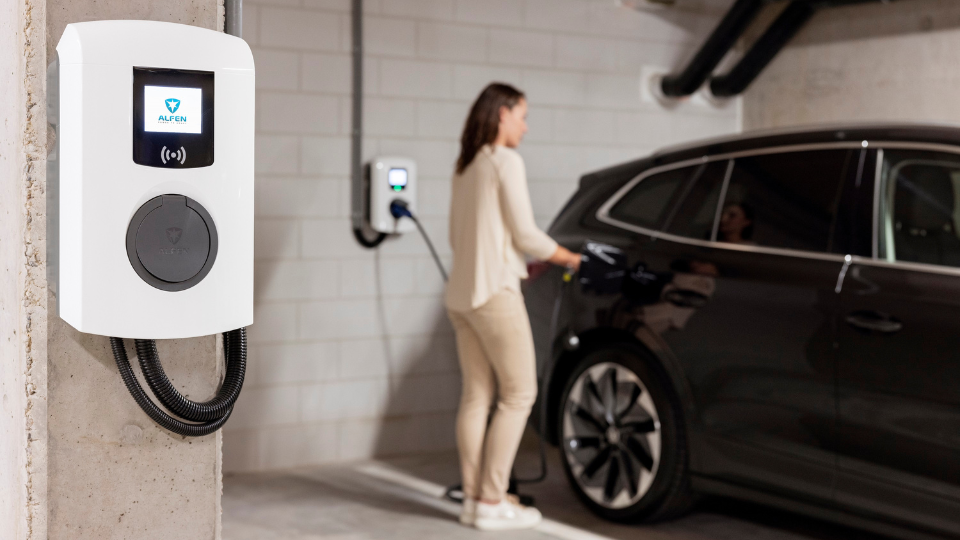 Laadpunt garage, vrouw zit haar auto te laden.