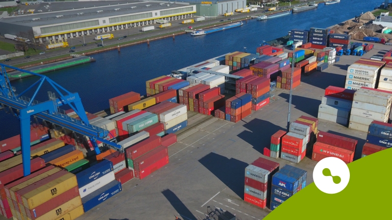 Een containeroverslag naast een kanaal
