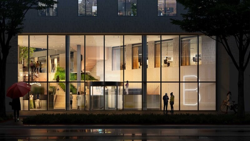 Een tekening van een gebouw met glazen pui in de avond